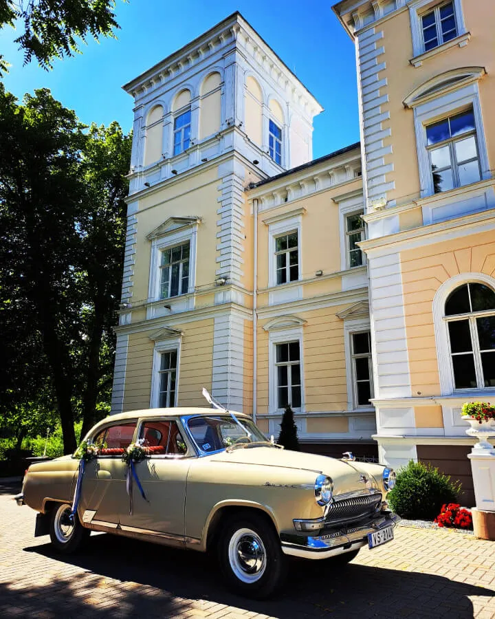 Retro kāzu auto ar lentēm pie Igates pils