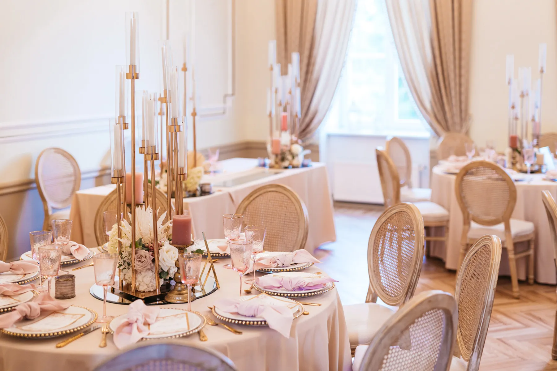 Festliche Tische mit hohen Kerzen und Blumen im Schlosssaal